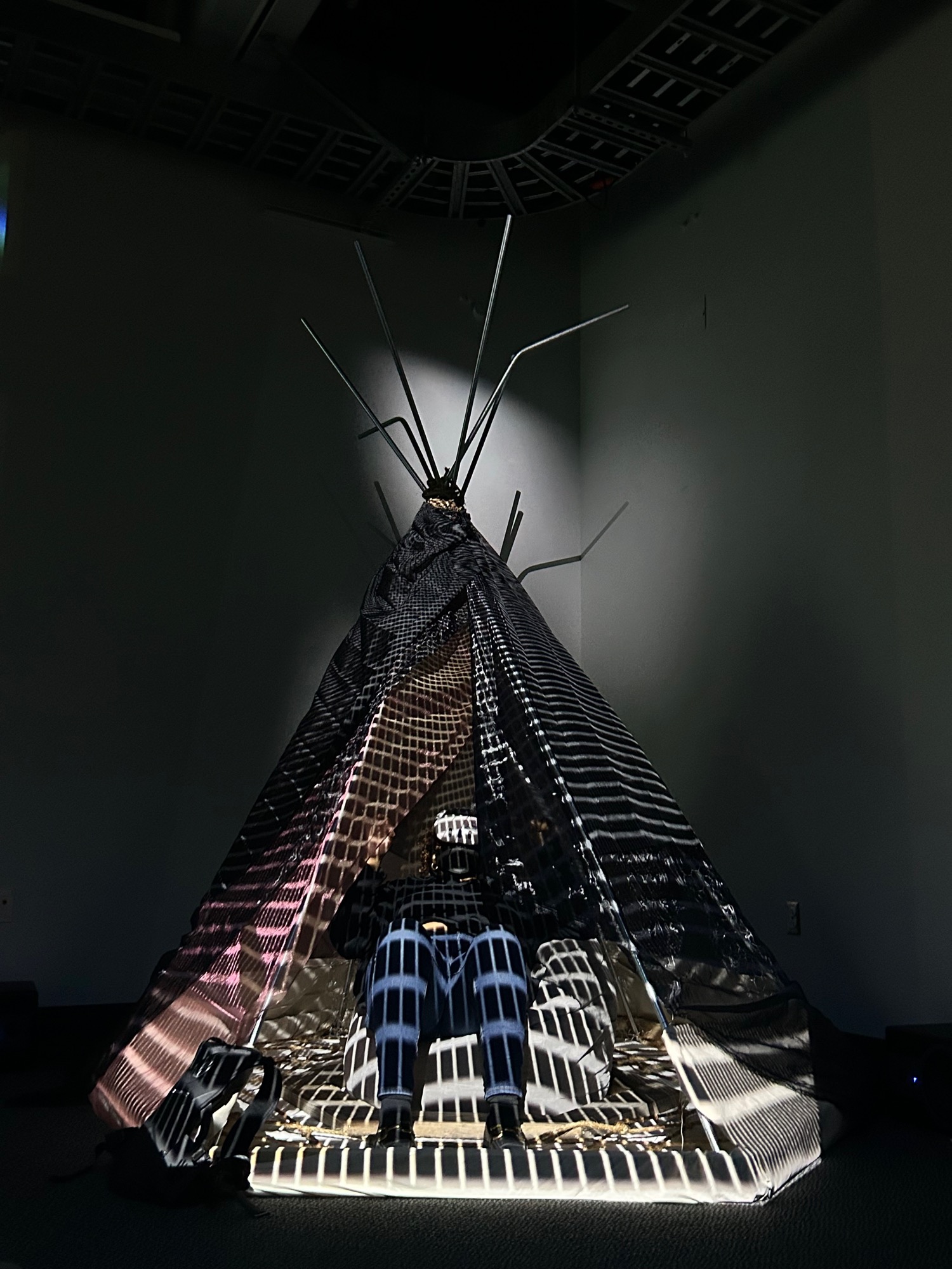 Built tent structure in a dark room with a projected grid mapped across it.